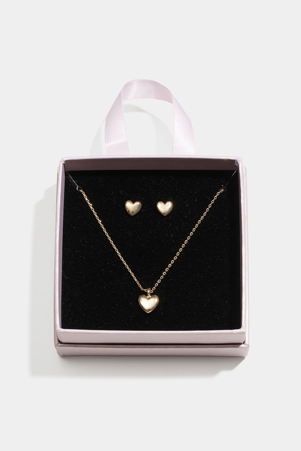 Guldfarvet smykkesæt med hjerter i en gaveæske