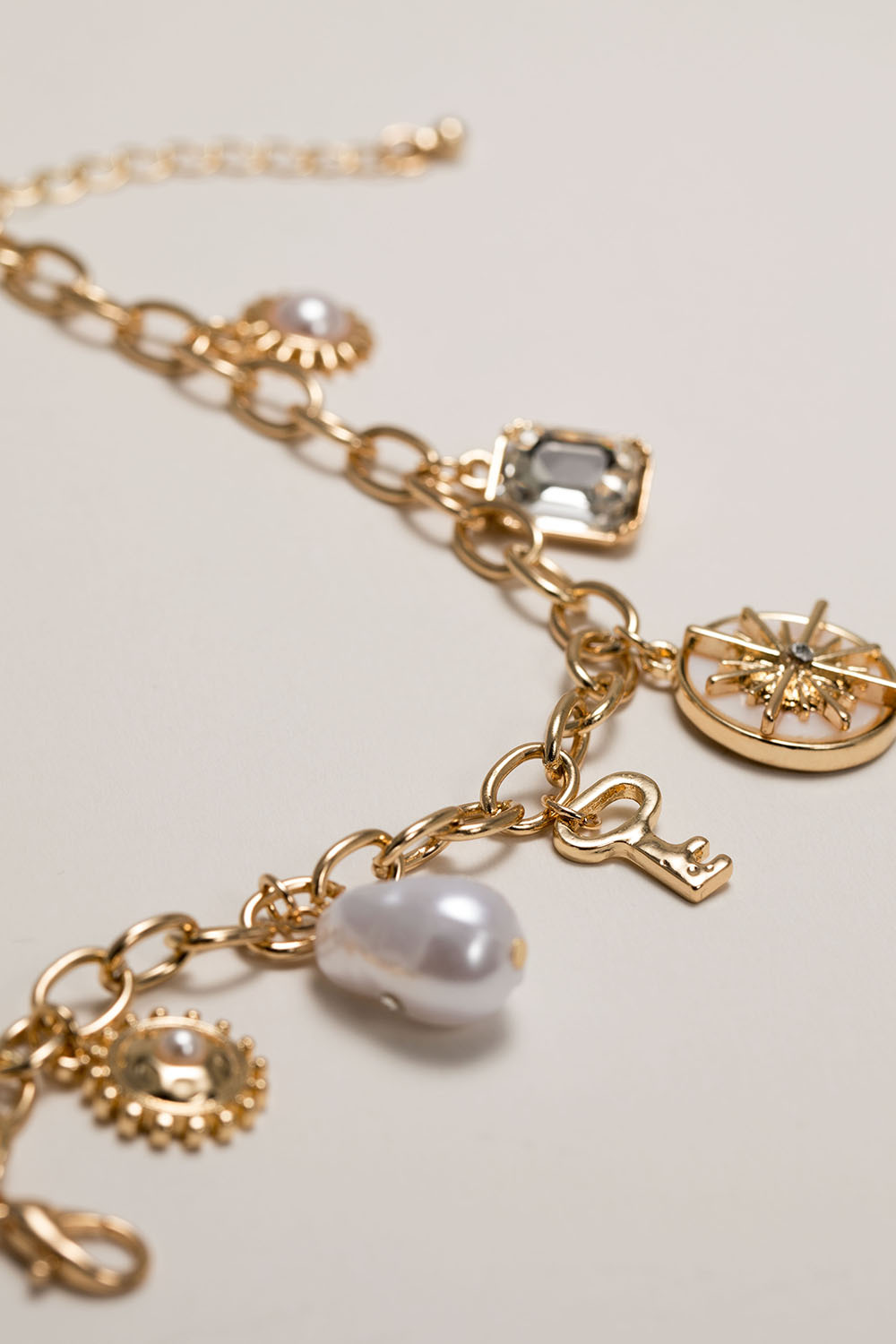 Guldfarvede armbånd med charms