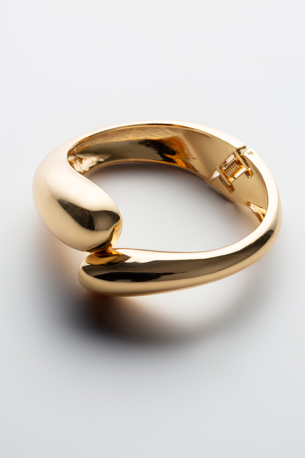 Guldfarvet bred armring med afrundede former