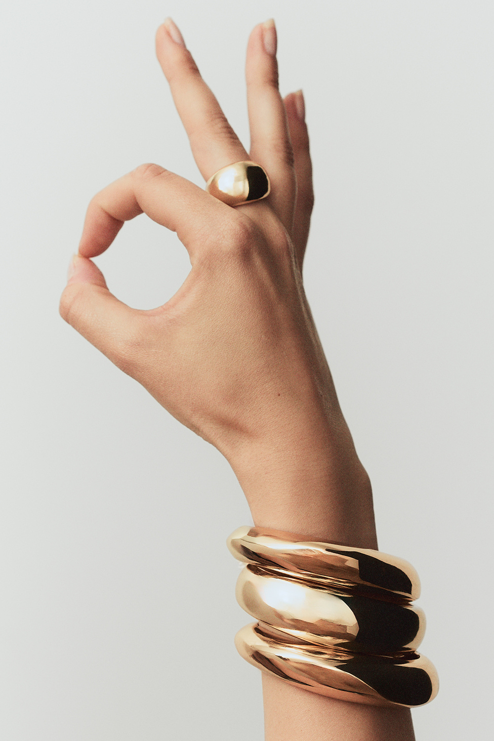 Guldfarvet manchetarmbånd med organisk form