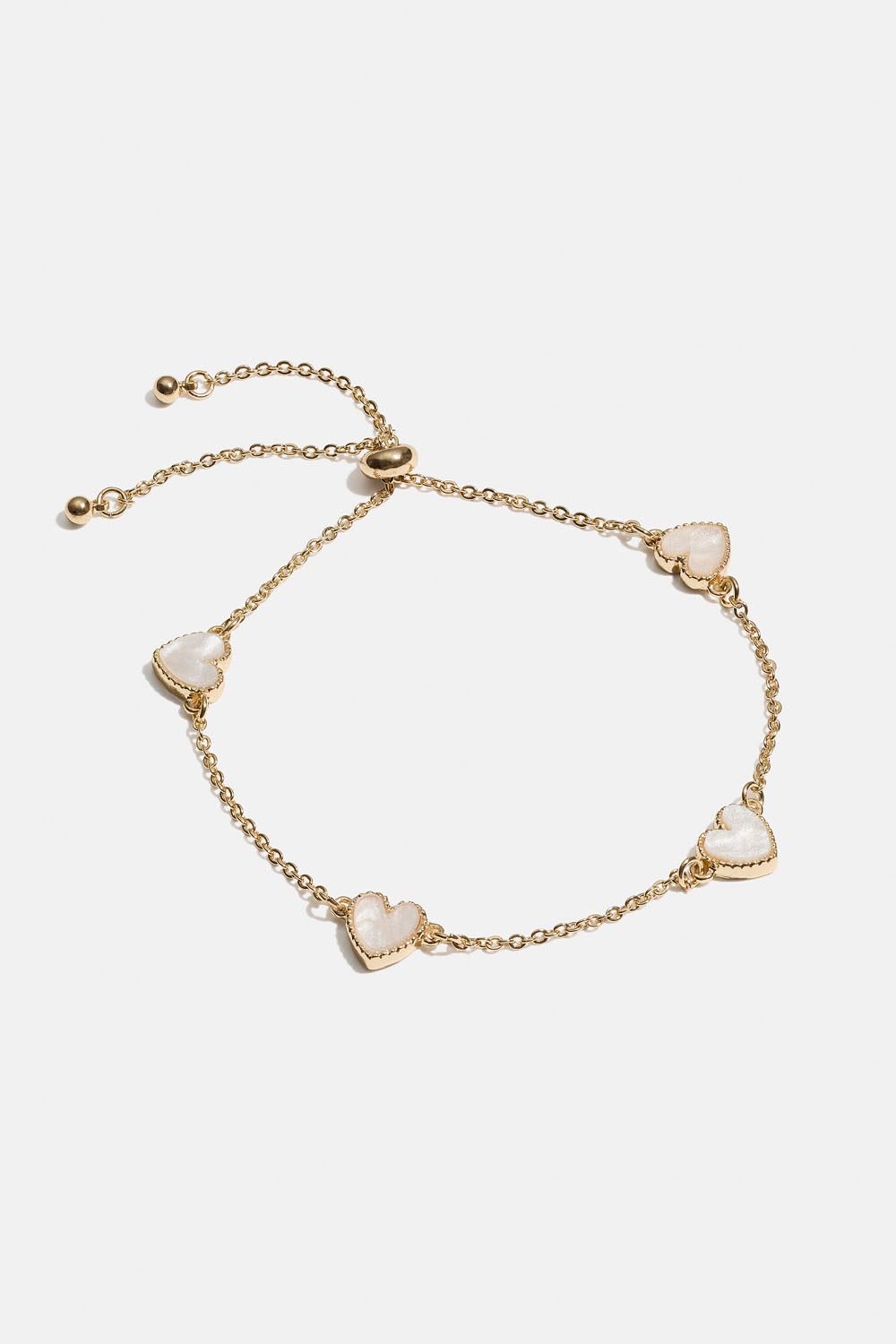 Guldfarvet armbånd med hvide hjerter