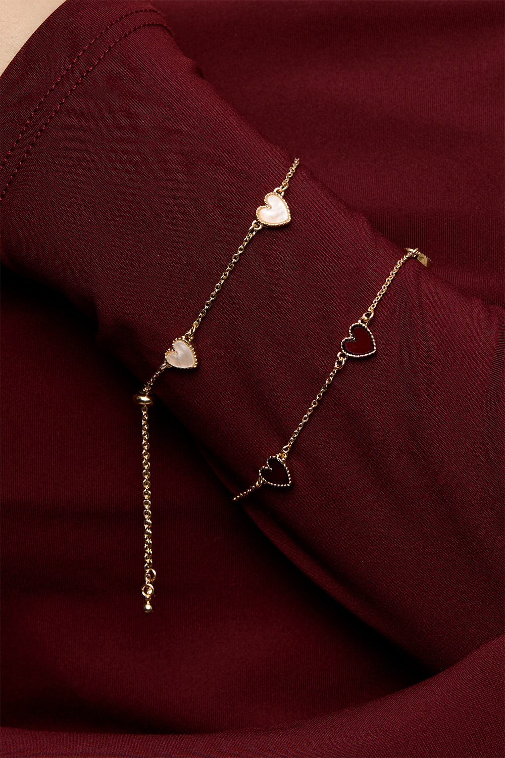 Guldfarvet armbånd med røde hjerter