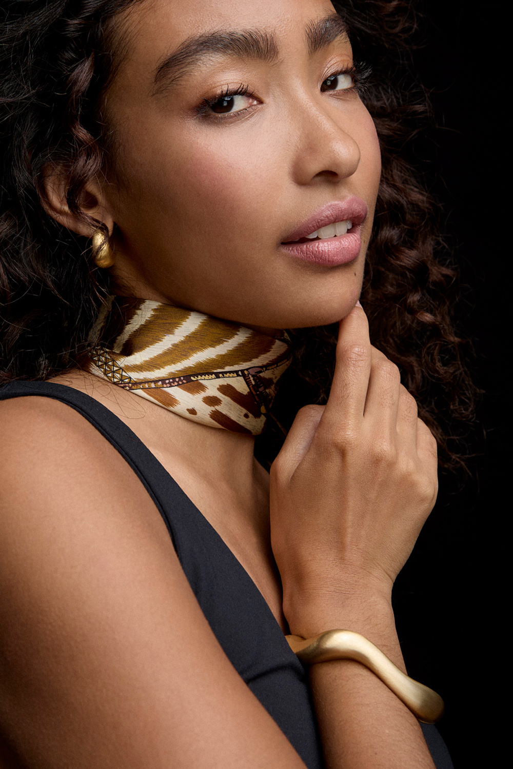 Guldfarvet armbånd med bølgeform og børstet finish