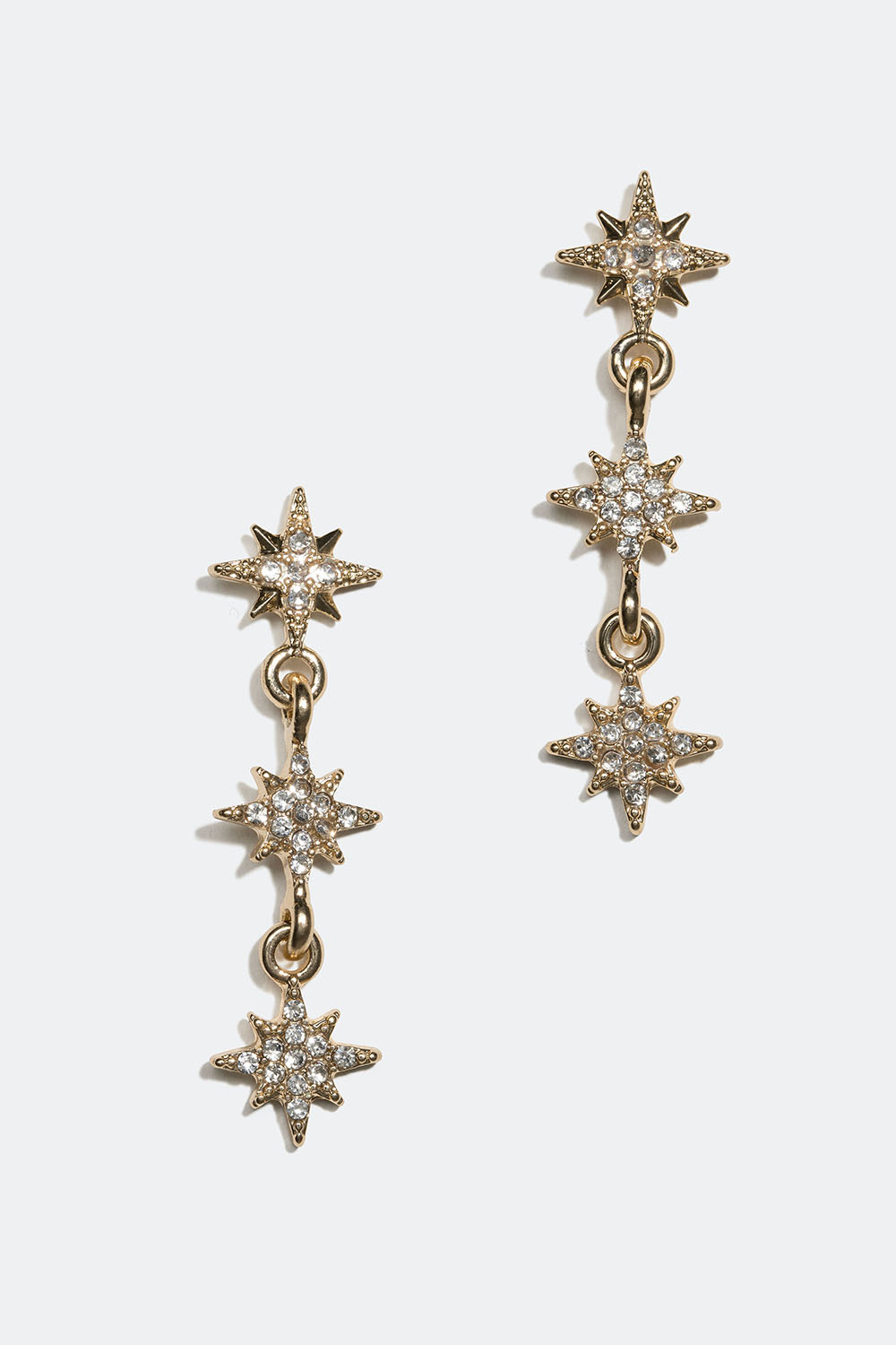 Guldfarvede øreringe med små stjerner og glassten