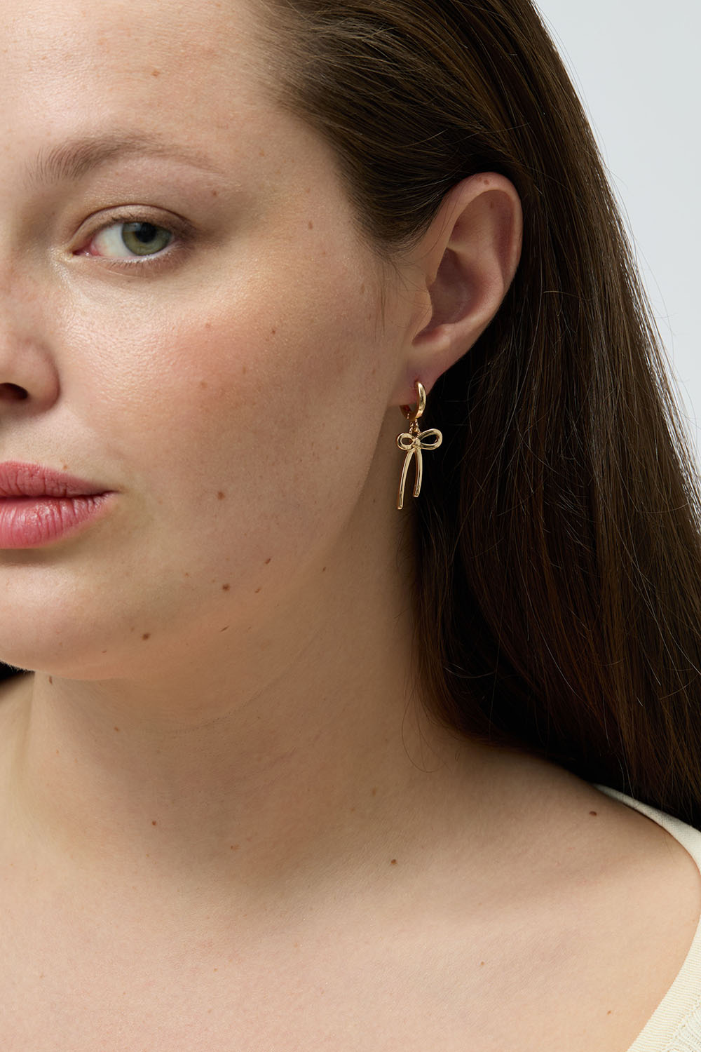 Små guldfarvede hoops med sløjfer