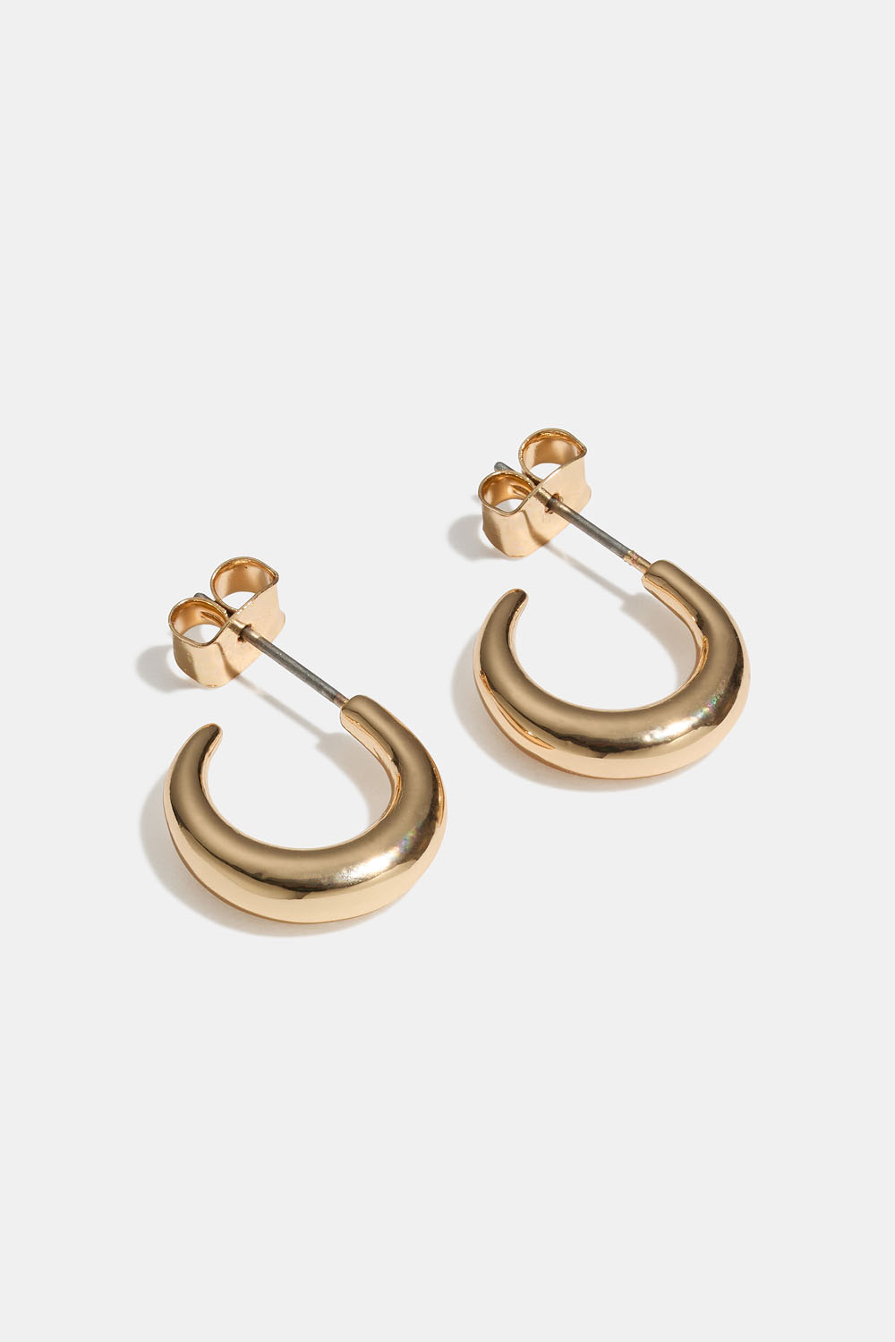 Små, guldfarvede runde creoler