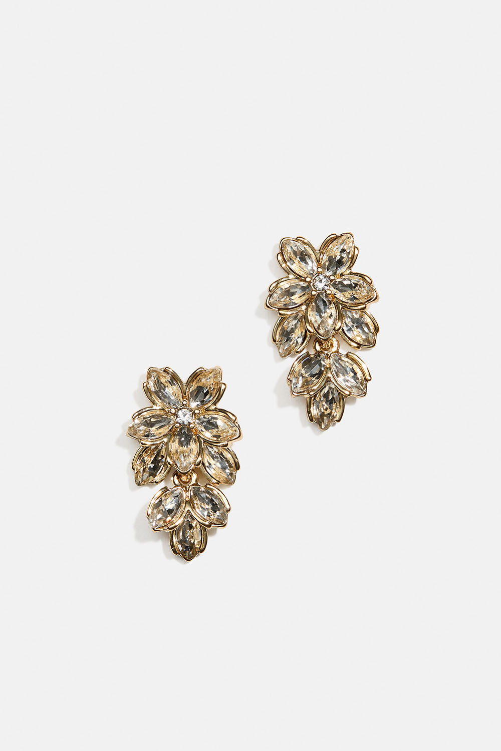 Guldfarvede øreringe med blomster, glassten og blade