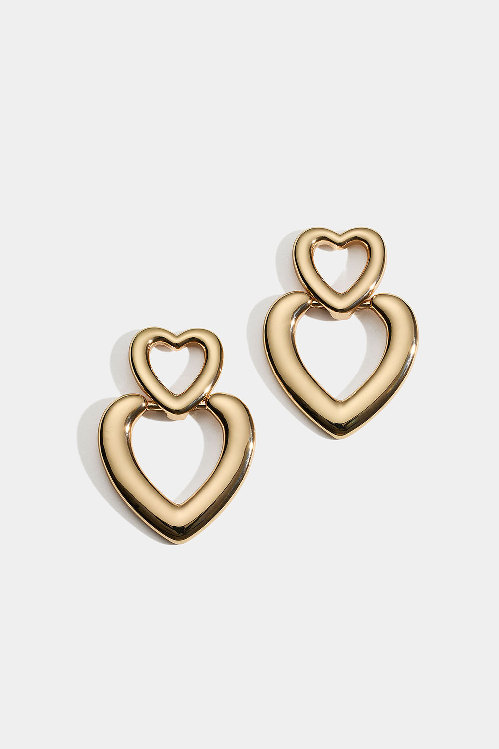 Guldfarvede øreringe med to hjerter