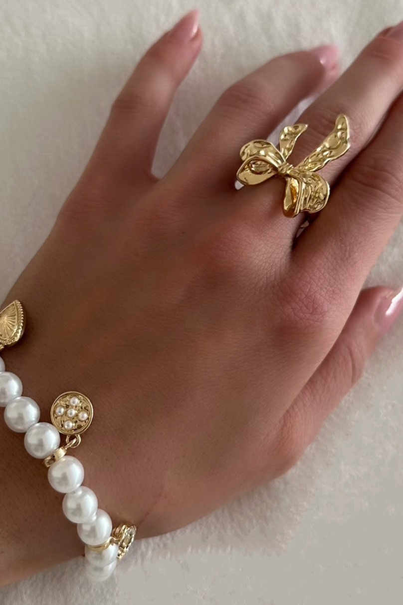 Guldfarvet ring med hamret sløjfe