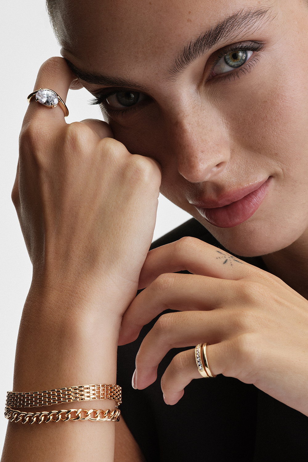 Guldfarvet ring i bølget design med oval glassten
