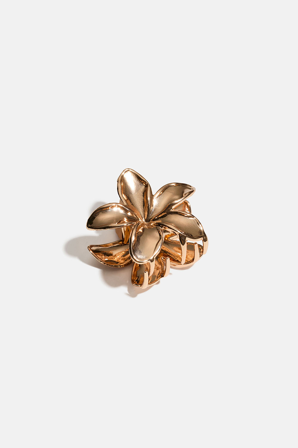 Lille blomsterformet hårklemme i guldfarvet metal