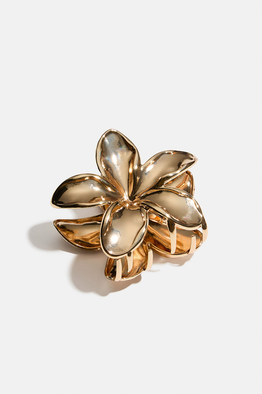Blomsterformet hårklemme i guldfarvet metal